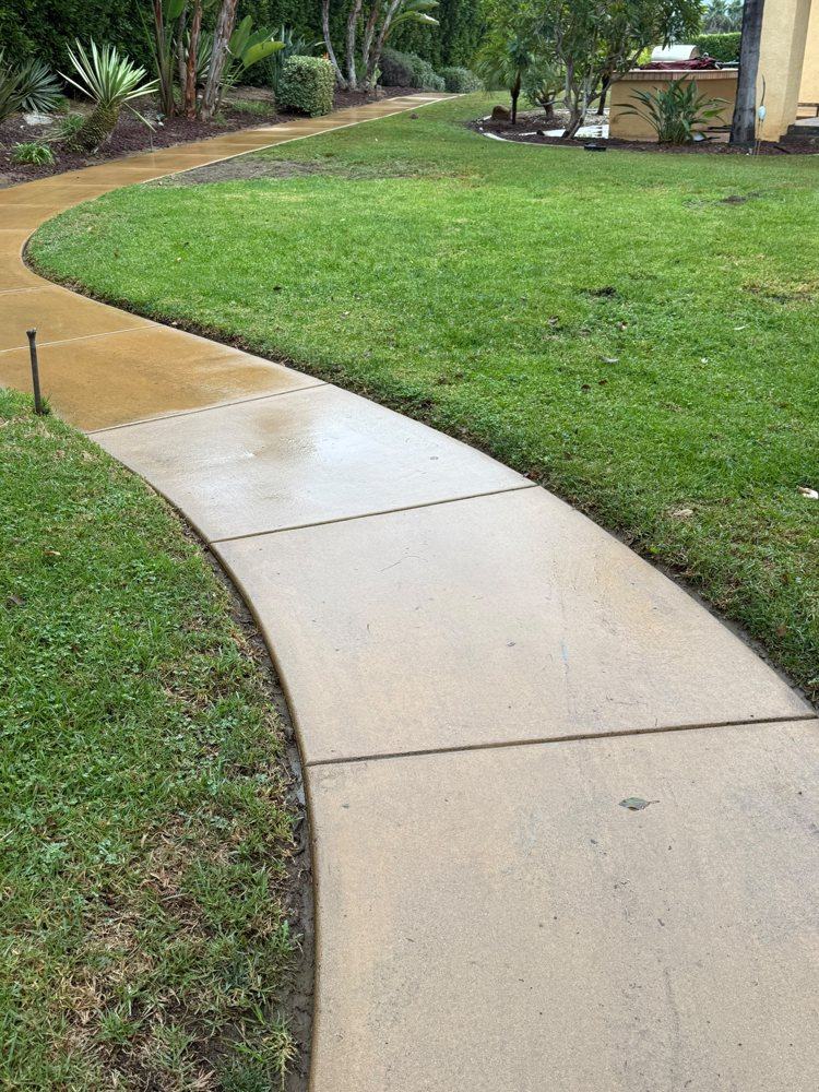Concrete walkway half washed, showing the clean line