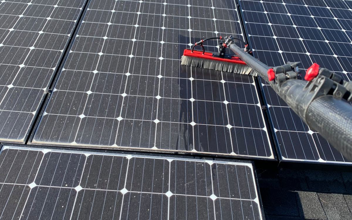 Our crew cleaning solar panels with a soft brush