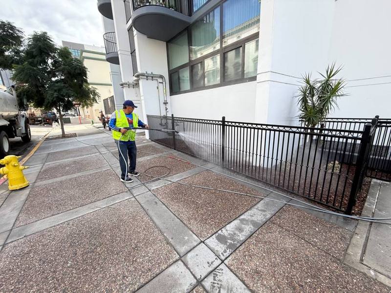 Crew pressure washing a downtown sidewalk